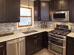Modern kitchen with dark cabinets, stainless steel appliances, and granite countertops.