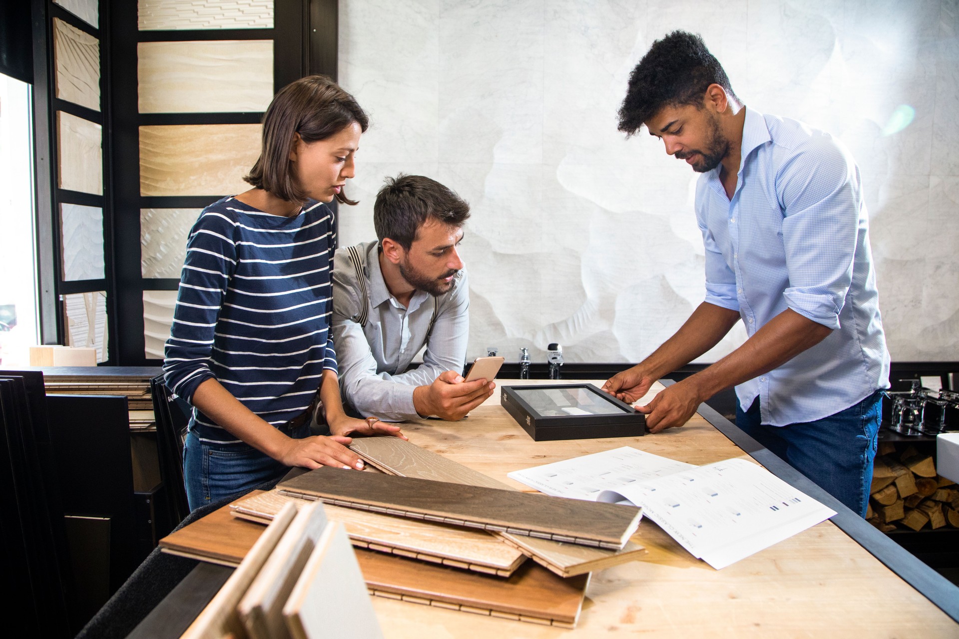 Shop attendant opening a small display case to a couple of shoppers in a home improvement store